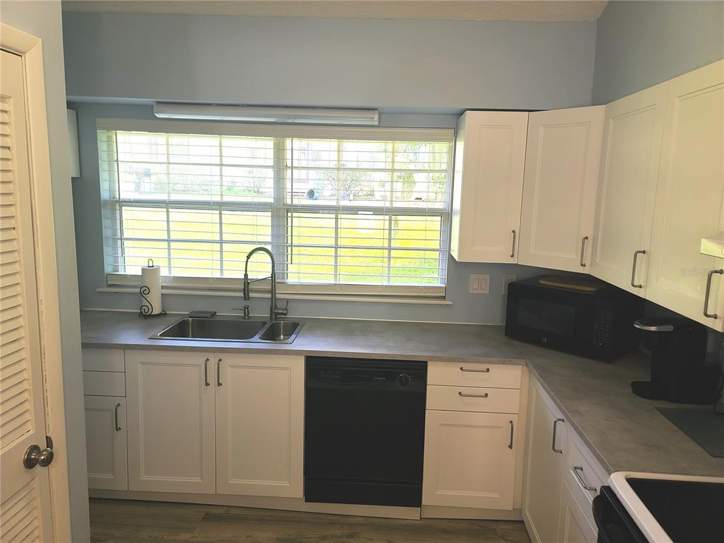 11001 Southeast Sunset Harbor Road, Unit C27 Summerfield, FL 34491 - Photo 15 of 53 a kitchen with granite countertop a sink and a stove