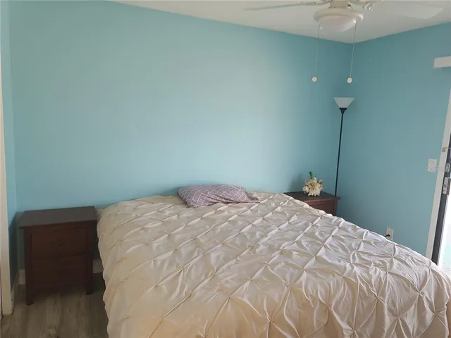 a bedroom with a bed and a chandelier fan