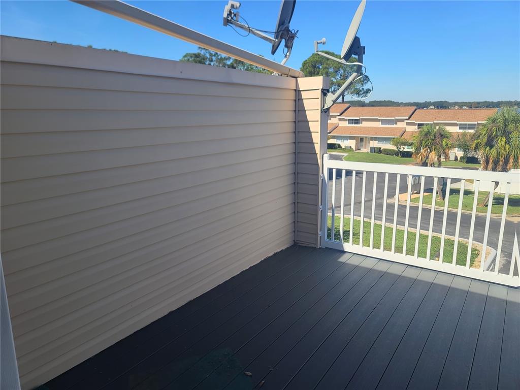 11001 Southeast Sunset Harbor Road, Unit C27 Summerfield, FL 34491 - Photo 26 of 53 a view of a balcony with wooden floor