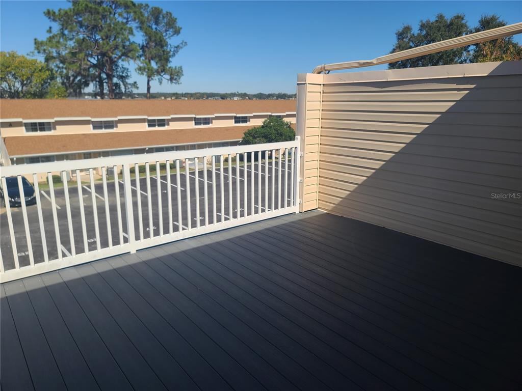 11001 Southeast Sunset Harbor Road, Unit C27 Summerfield, FL 34491 - Photo 29 of 53 a view of a balcony with wooden floor