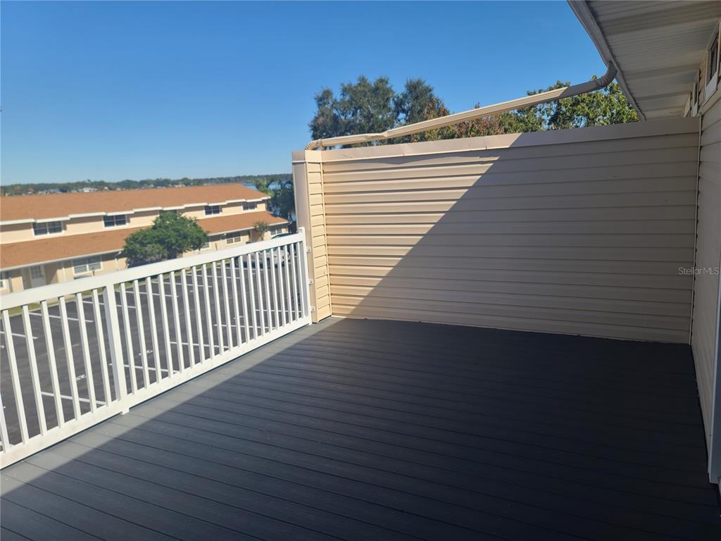 11001 Southeast Sunset Harbor Road, Unit C27 Summerfield, FL 34491 - Photo 30 of 53 a view of a balcony with wooden floor