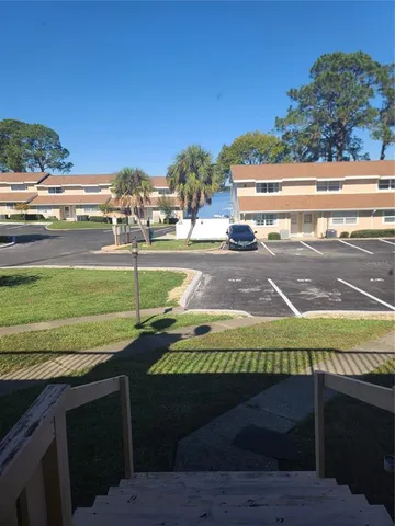 a view of a swimming pool with a lawn chairs under an umbrella