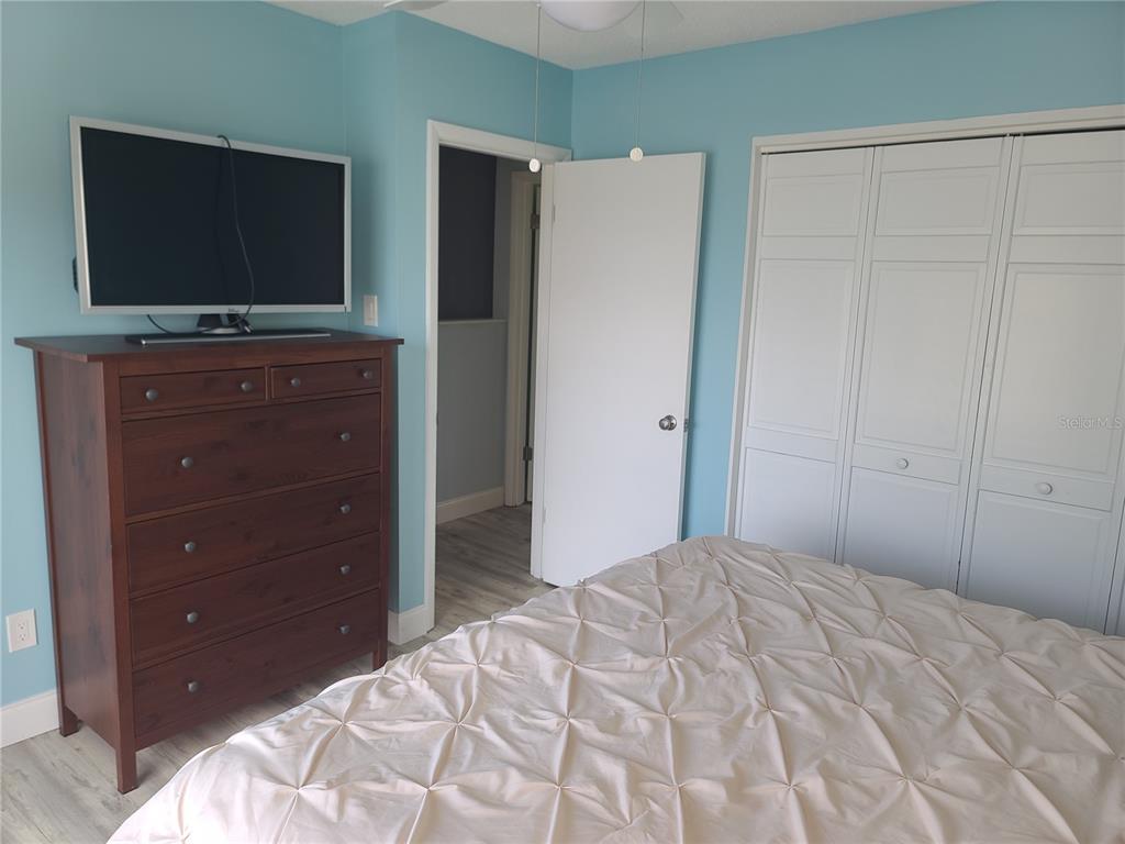 11001 Southeast Sunset Harbor Road, Unit C27 Summerfield, FL 34491 - Photo 32 of 53 a bedroom with a bed and a flat screen tv in it