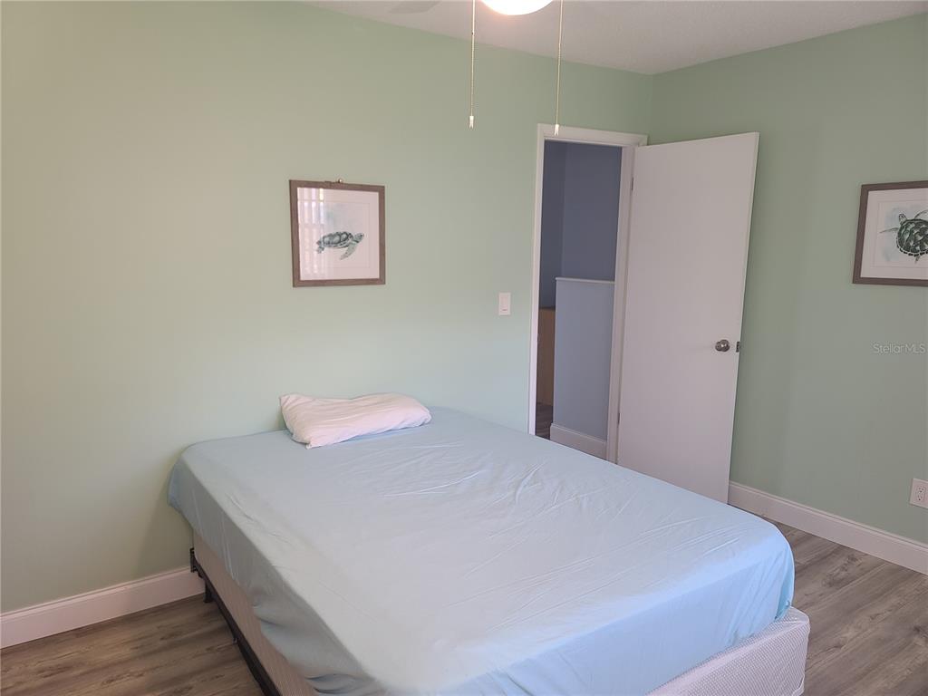 11001 Southeast Sunset Harbor Road, Unit C27 Summerfield, FL 34491 - Photo 35 of 53 a bedroom with a bed and wooden floor