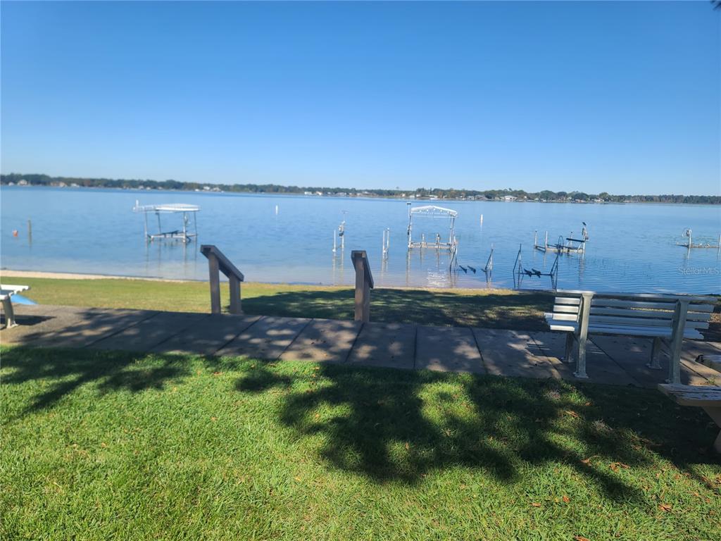 11001 Southeast Sunset Harbor Road, Unit C27 Summerfield, FL 34491 - Photo 42 of 53 a swimming pool with an outdoor seating and trees in the background