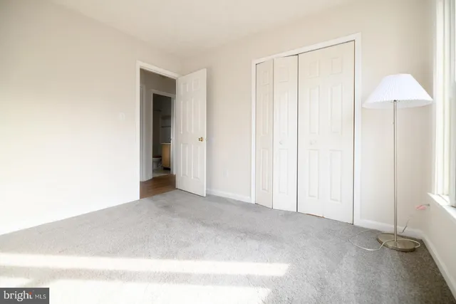 an empty room with windows and closet