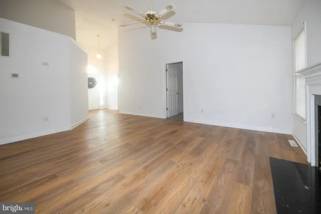 a view of empty room with wooden floor and window