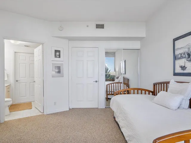a spacious bedroom with a bed a lamp and a chandelier