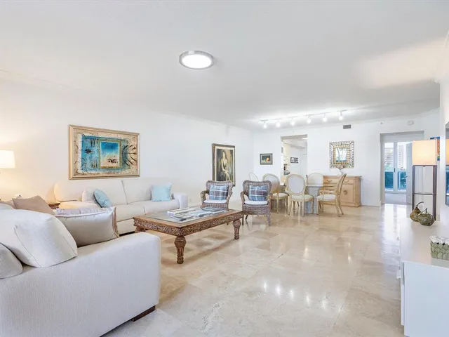 a living room with couches and a dining table with wooden floor