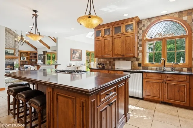 a kitchen with stainless steel appliances granite countertop a sink a counter space and a view of living room