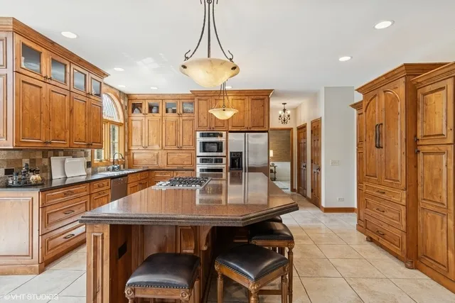a kitchen with a table chairs refrigerator and cabinets