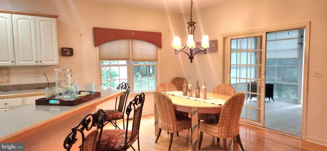 a dining room with furniture a chandelier and wooden floor