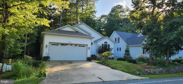 a front view of a house with a garden and garage
