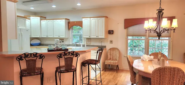 a dining room filled chandelier and wooden floor