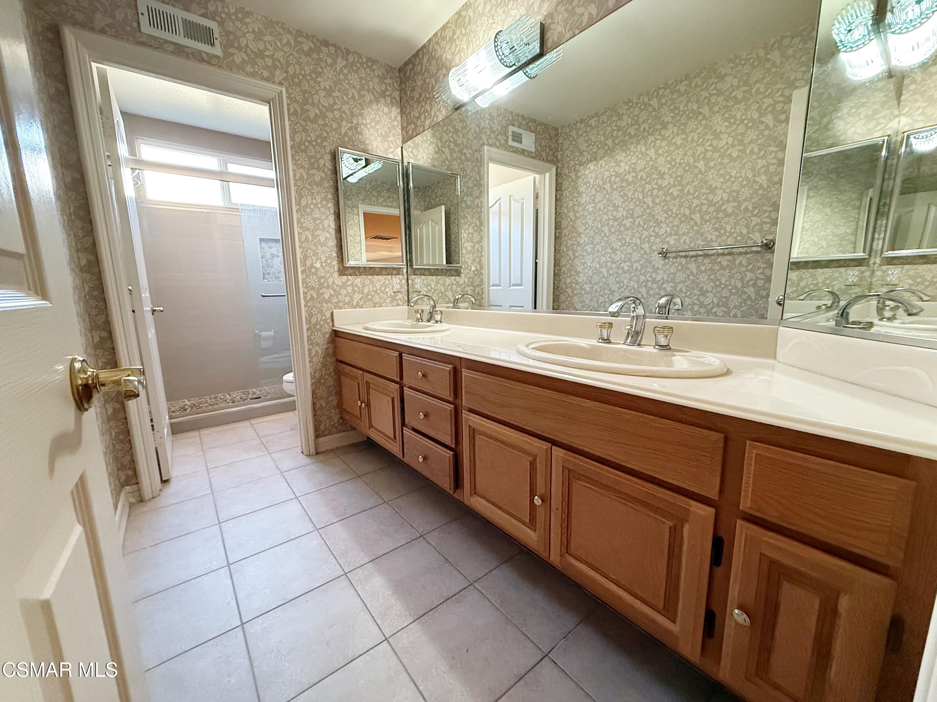 267 High Meadow Street Simi Valley, CA 93065 - Photo 27 of 36 a spacious bathroom with a double vanity sink a mirror and a shower