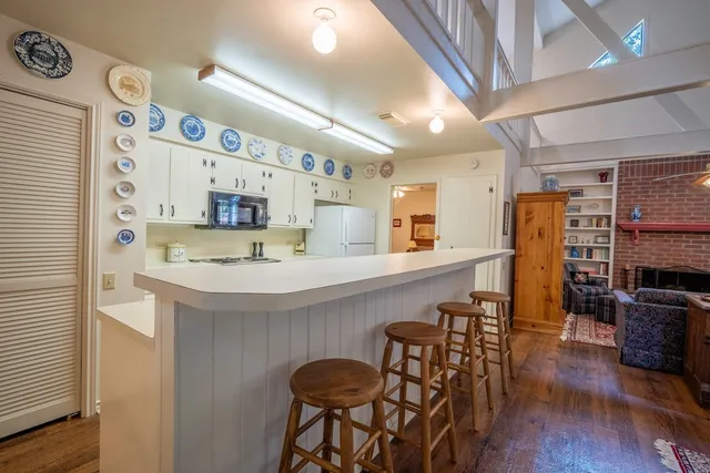 a kitchen with stainless steel appliances kitchen island granite countertop a table chairs and a refrigerator