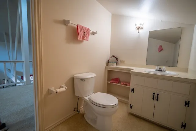 a bathroom with a sink vanity mirror and toilet