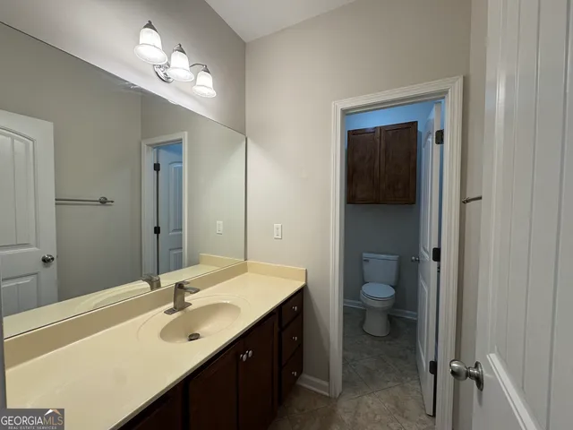 a view of an empty room with wooden floor and a ceiling fan
