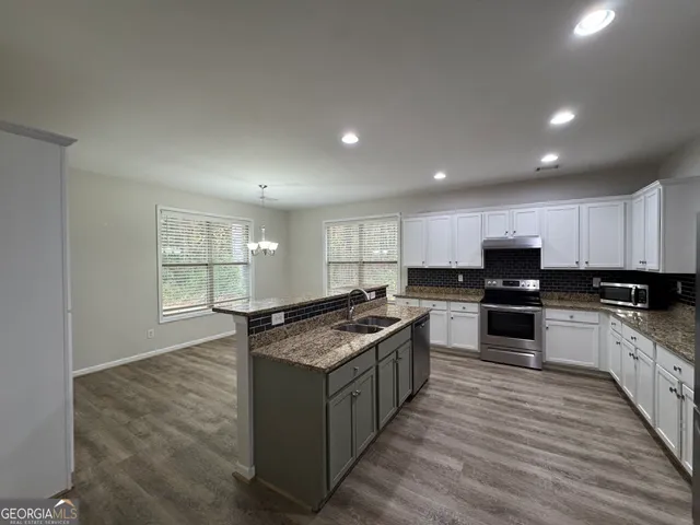 a kitchen with stainless steel appliances granite countertop a stove a sink and a refrigerator