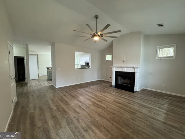 a view of empty room with fireplace and wooden floor