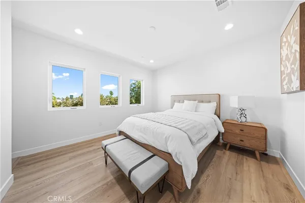 a spacious bedroom with a bed and a dresser