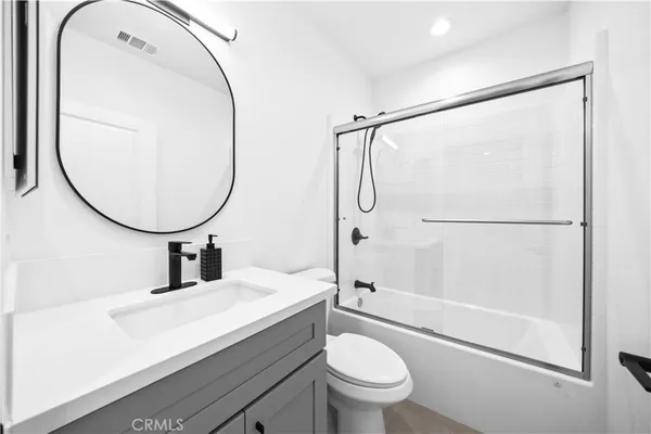 a bathroom with a sink mirror toilet and shower
