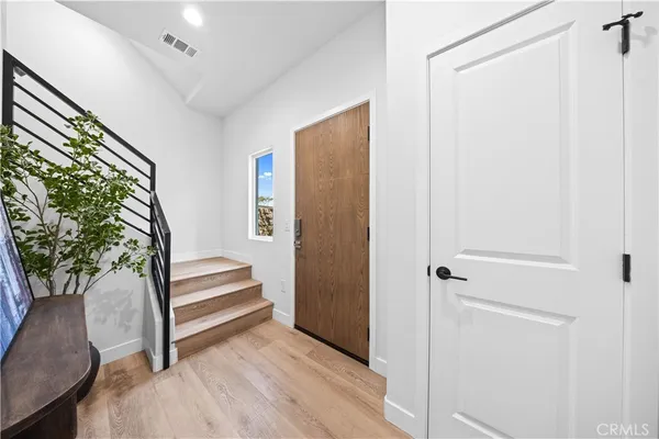 a view of front door with wooden floor and stairs