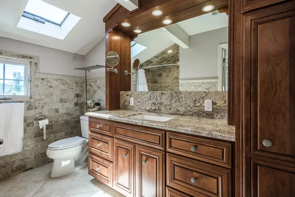 a bathroom with a granite countertop sink toilet and shower