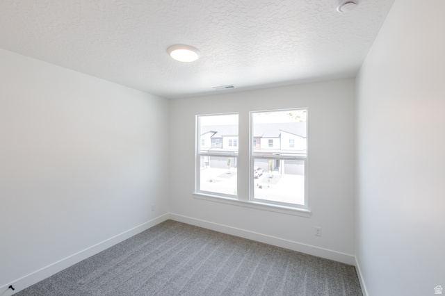5224 South Acacia Drive, Unit 809 Mapleton, UT 84664 - Photo 19 of 23 Bright room featuring two large windows, white walls, gray patterned carpet, white baseboards, and a flush-mount ceiling light