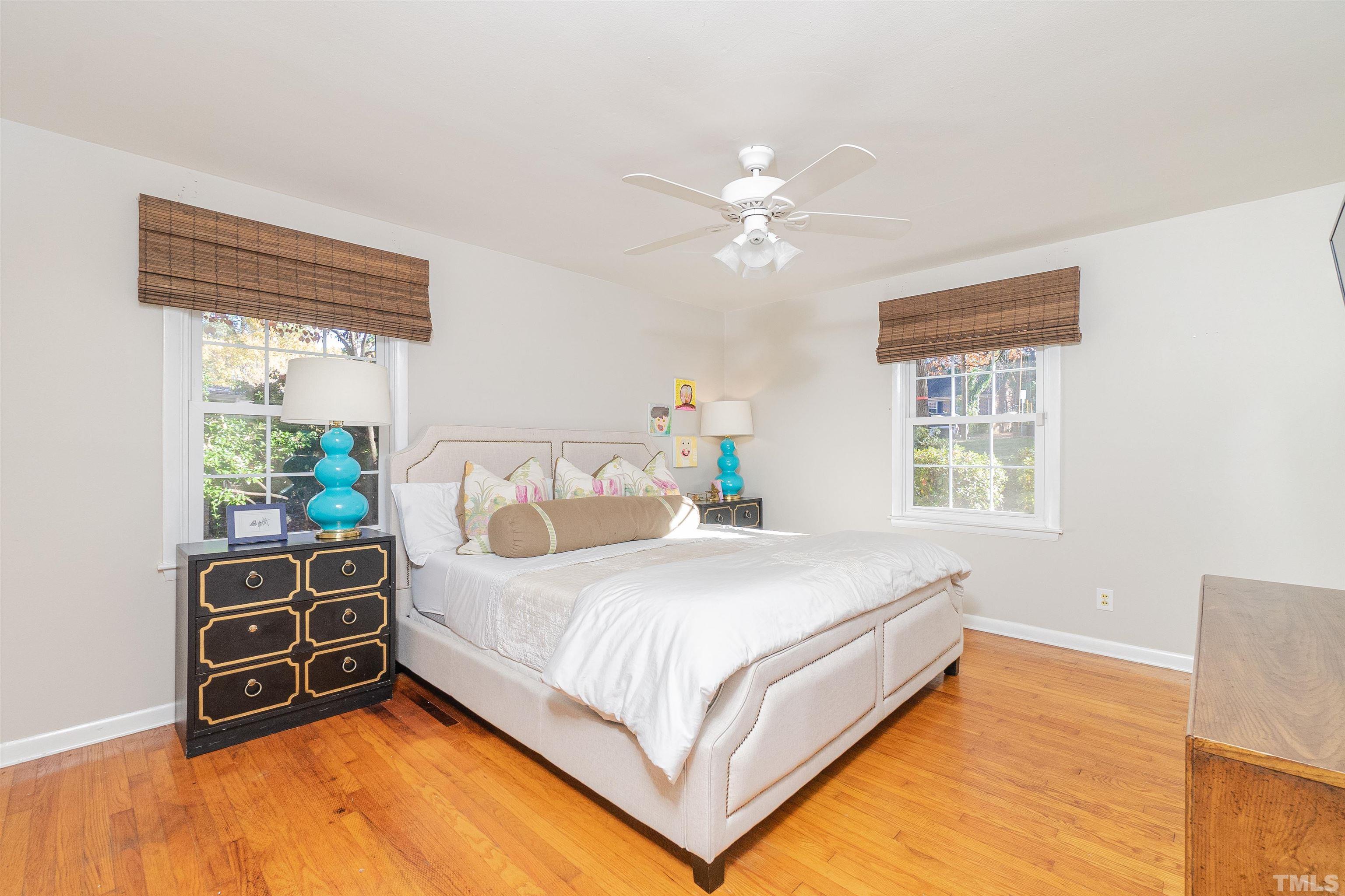 604 Davidson Street Raleigh, NC 27609 - Photo 14 of 28 a bedroom with a bed a dresser with windows