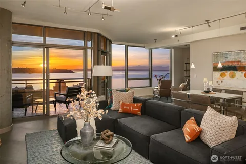 a living room with furniture and floor to ceiling windows