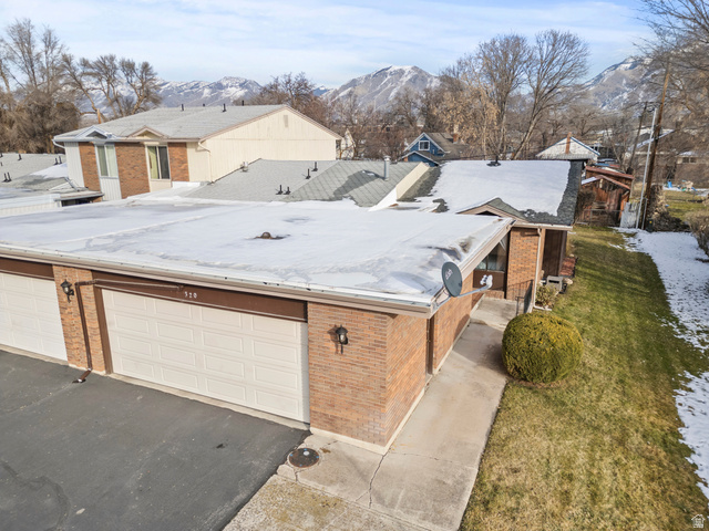 320 North 150 West Logan, UT 84321 - Photo 20 of 22 View of front facade featuring brick siding, a mountain view, asphalt driveway, and a garage
