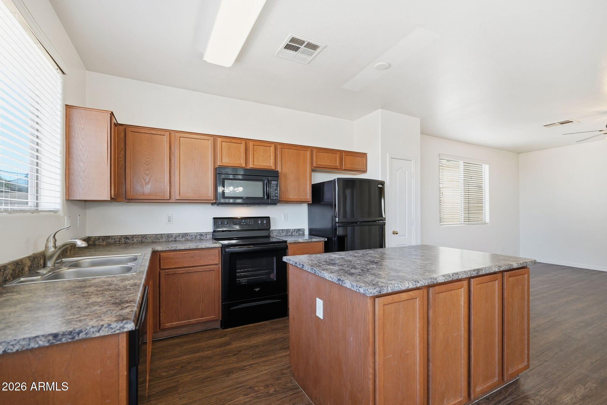 9360 West Payson Road Tolleson, AZ 85353 - Photo 11 of 33 a kitchen with stainless steel appliances granite countertop a sink stove microwave and refrigerator