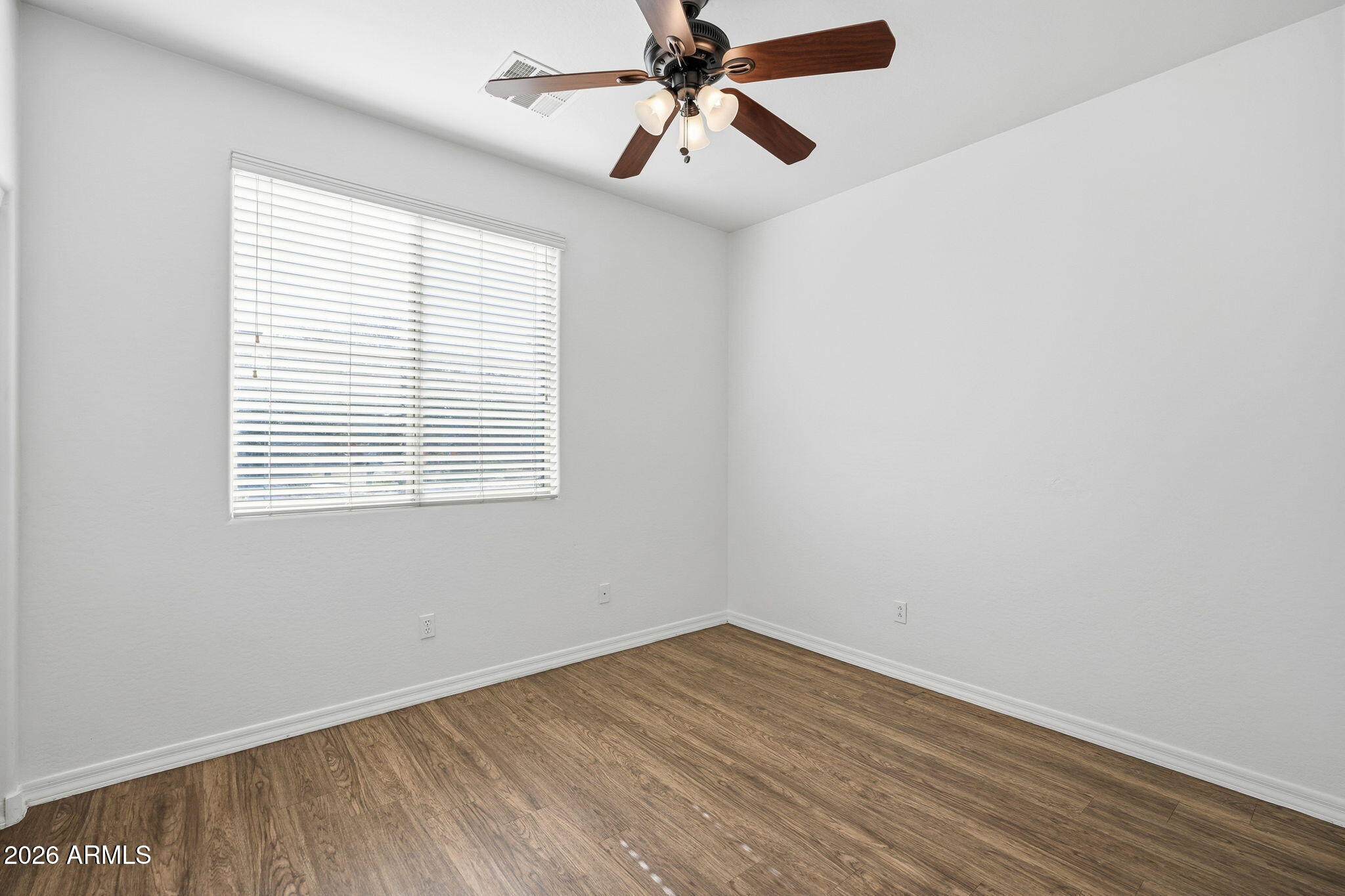 9360 West Payson Road Tolleson, AZ 85353 - Photo 13 of 33 wooden floor in an empty room with a window