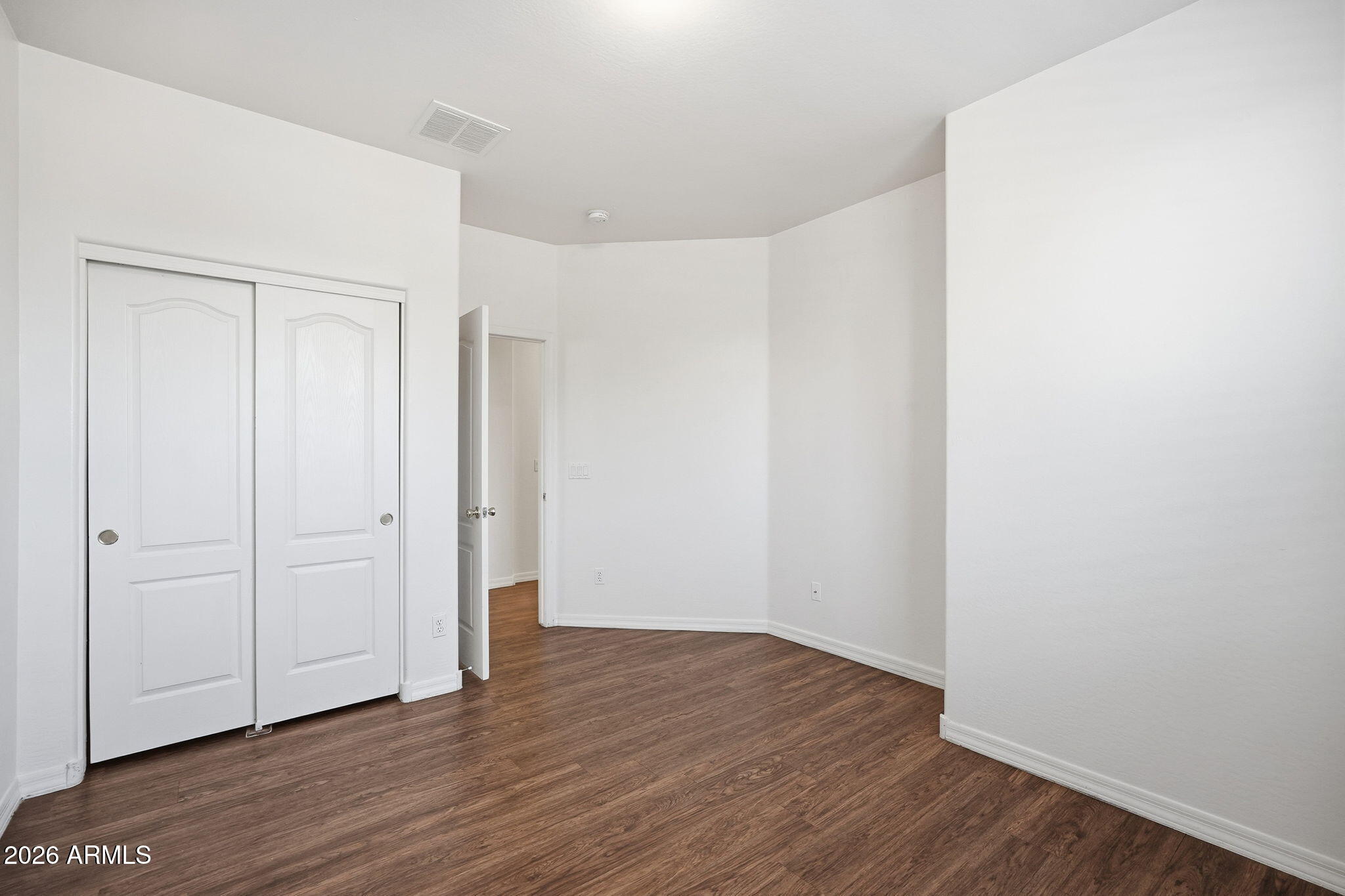 9360 West Payson Road Tolleson, AZ 85353 - Photo 16 of 33 a view of an empty room with wooden floor