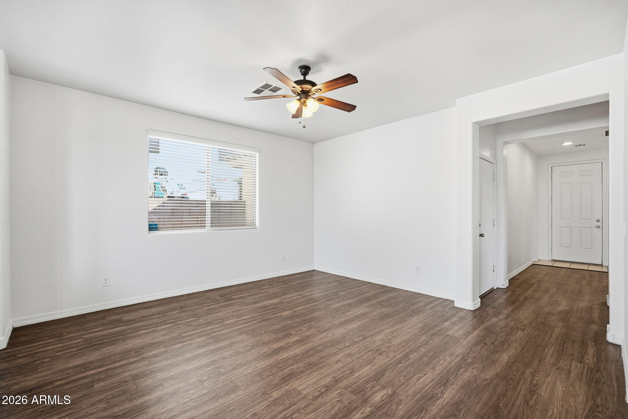 9360 West Payson Road Tolleson, AZ 85353 - Photo 18 of 33 an empty room with wooden floor chandelier fan and windows