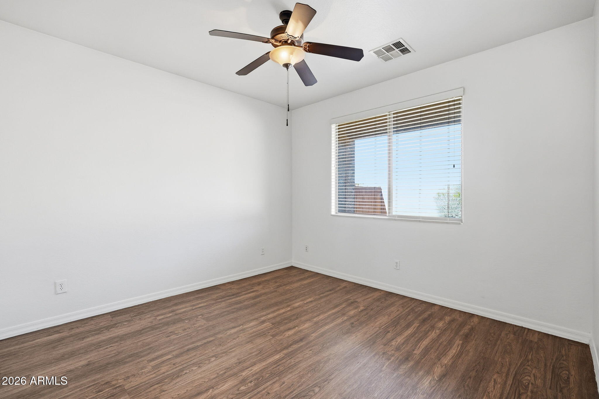 9360 West Payson Road Tolleson, AZ 85353 - Photo 19 of 33 a view of empty room with wooden floor and fan