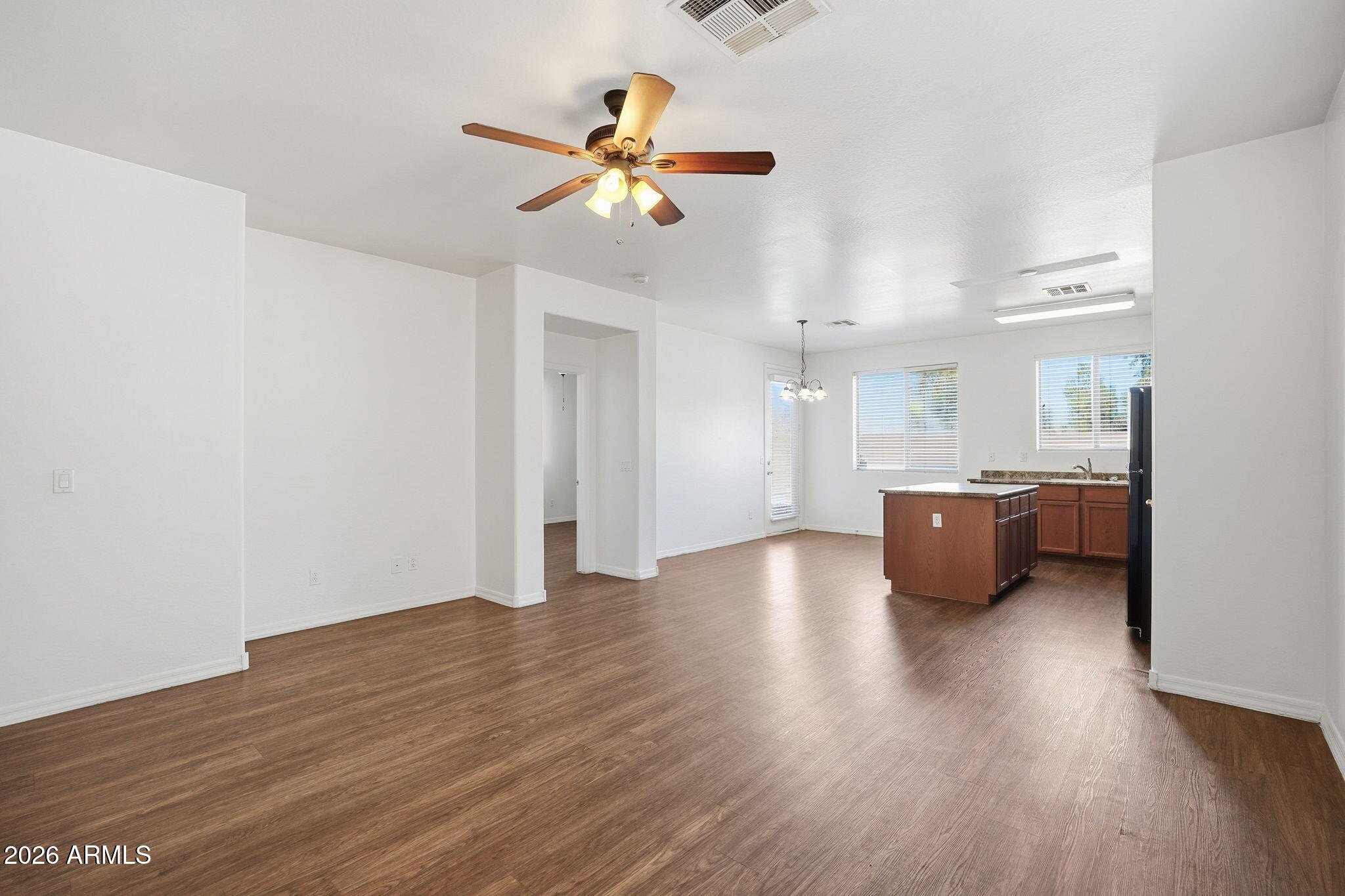9360 West Payson Road Tolleson, AZ 85353 - Photo 7 of 33 a view of a kitchen with a sink a ceiling fan and wooden floor