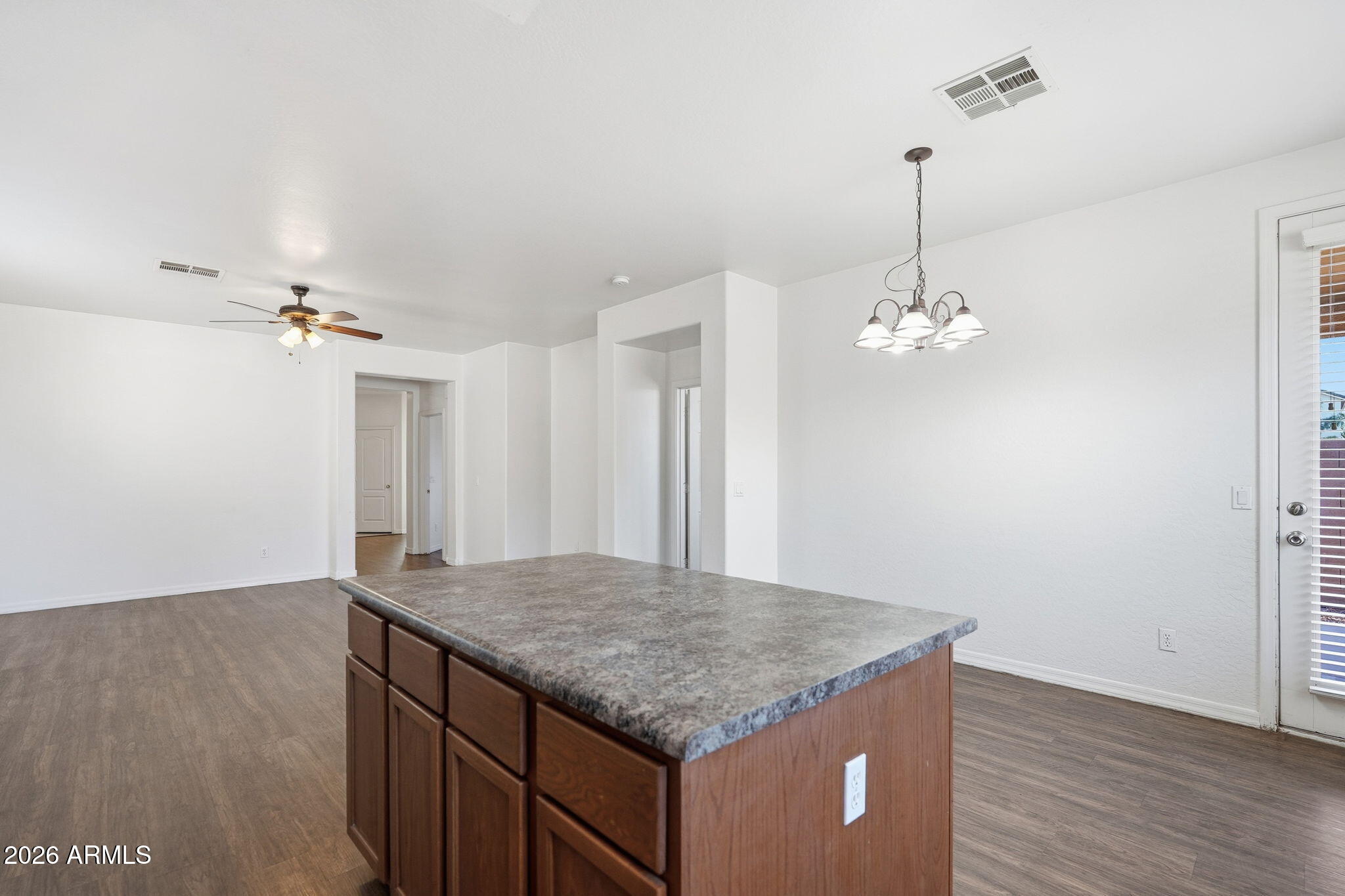9360 West Payson Road Tolleson, AZ 85353 - Photo 10 of 33 a kitchen with kitchen island a counter space and wooden floor