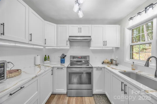 a kitchen with cabinets appliances a sink and a window