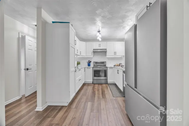 a kitchen with cabinets a sink and wooden floor