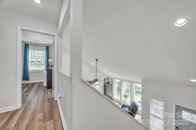 a view of a hallway with wooden floor and staircase