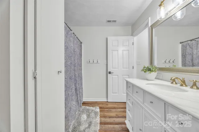 a bathroom with a double vanity sink mirror and shower