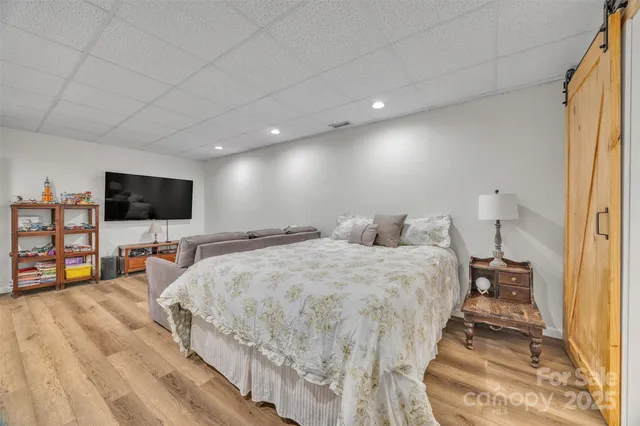 a spacious bedroom with a bed and a flat screen tv