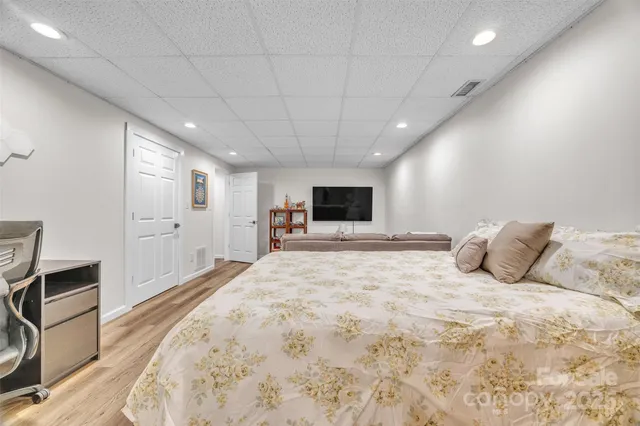 a large bedroom with a bed and a flat screen tv