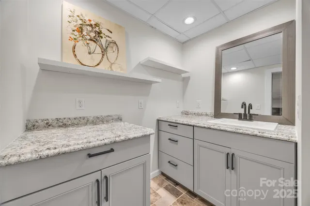 a bathroom with a granite countertop sink and a mirror