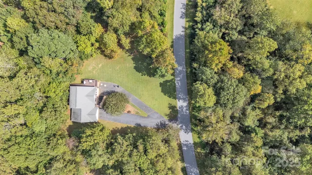 an aerial view of a residential houses with yard