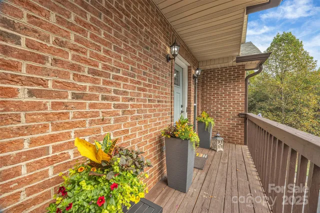 a view of a balcony with wooden floor and potted plants