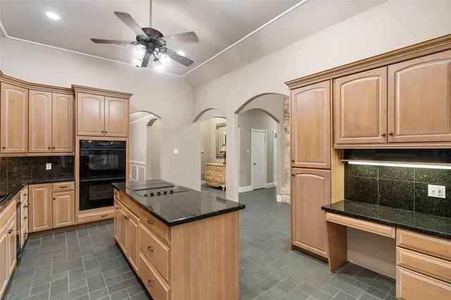 a kitchen with stainless steel appliances granite countertop a stove top oven a sink dishwasher a refrigerator and cabinets with wooden floor