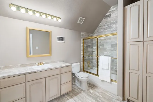 a spacious bathroom with a granite countertop sink toilet and shower